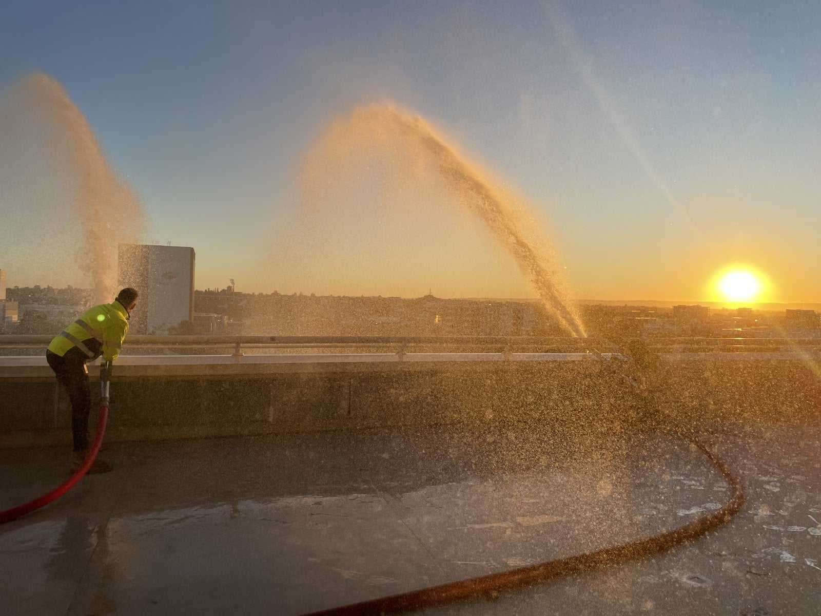 EFS technician testing fire hoses on a Perth rooftop at sunset